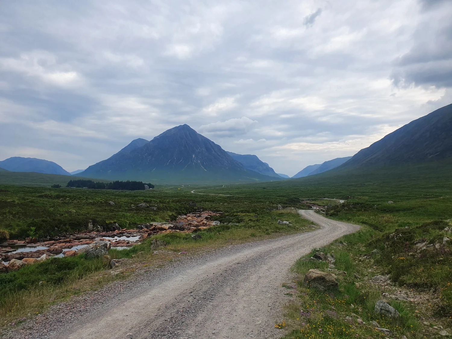 The Black Corries track winding across the moor towards Buachaille Etive Mòr, with the River Etive's rocky banks alongside